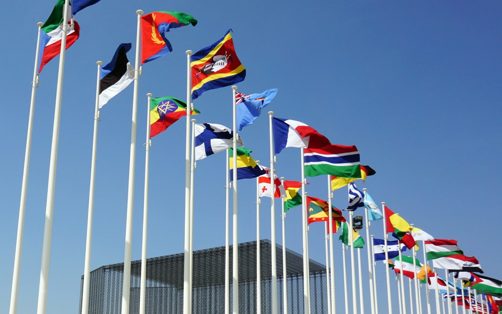 row of world flags against a blue sky