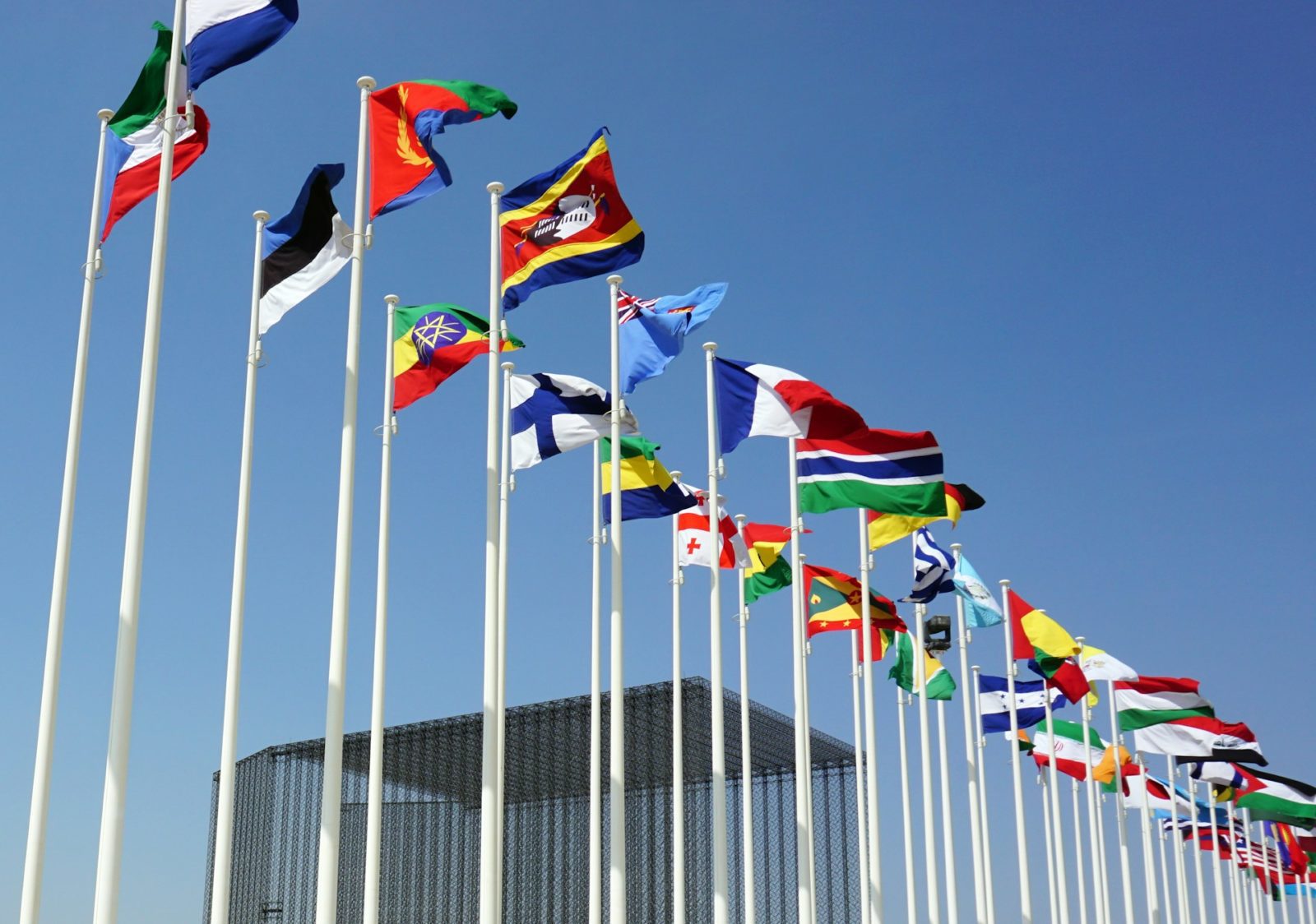 row of world flags against a blue sky