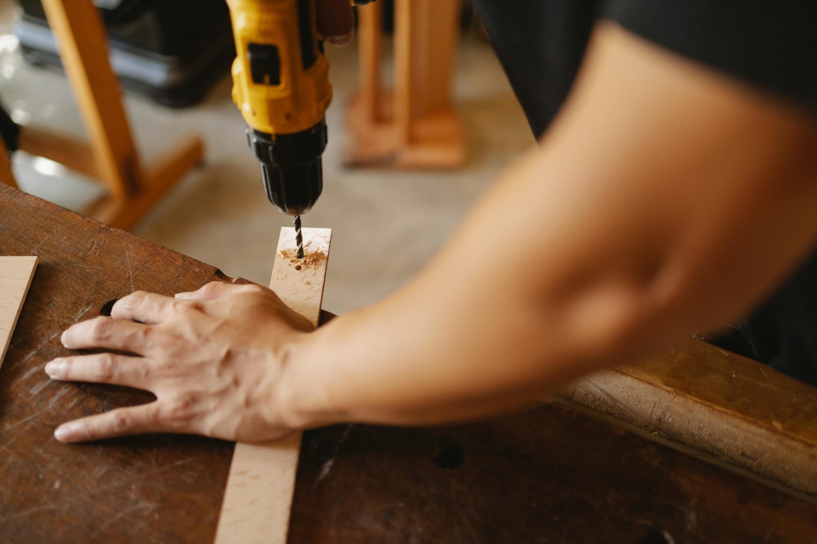 Worker drilling hole through wood
